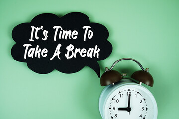 Fototapeta premium It's Time To Take A Break text on speech bubble with alarm clock on green background