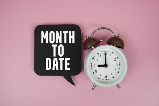 Month To Date text on speech bubble with alarm clock on pink background