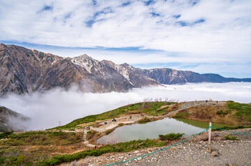 Hiking Route to Happo Pond and  the Japanese Alps mountains landscape with mist background on Hakuba Happo One in Hakuba, Nagano, Japan