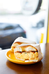 Bagel bread with scrambled egg and bacon.