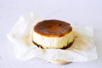 Cheesecake with baking paper on white marble table.