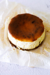 Cheesecake with baking paper on white marble table.