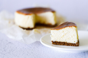 Cheesecake with baking paper on white marble table.