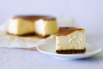 Cheesecake with baking paper on white marble table.