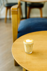 Cup of coffee latte art on wood table.