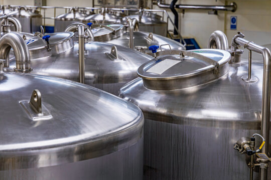 Stainless vertical steel tanks and pipes with pressure meter in equipment tank chemical cellar at the with stainless steel tanks cleaning
