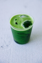 Iced matcha drink with water in a glass.
