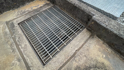 Industrial drainage pit covered with a steel grate, designed to manage wastewater and prevent accidents,