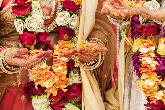 Close-up of Indian Bride and Groom Hands During Hindu Wedding Ritual  kundan jewelry, and intricate mehndi art