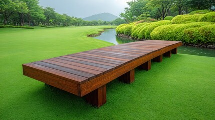 Obraz premium Tranquil wooden pathway leading to serene green landscape by water with lush trees and mountains in the background, perfect for relaxation and nature exploration
