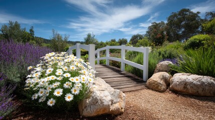 Obraz premium Serene Garden Landscape with White Wooden Bridge, Colorful Flowers, and Clear Blue Sky in a Peaceful Natural Setting with Greenery