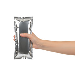 A hand holding a rectangular object wrapped in silver foil