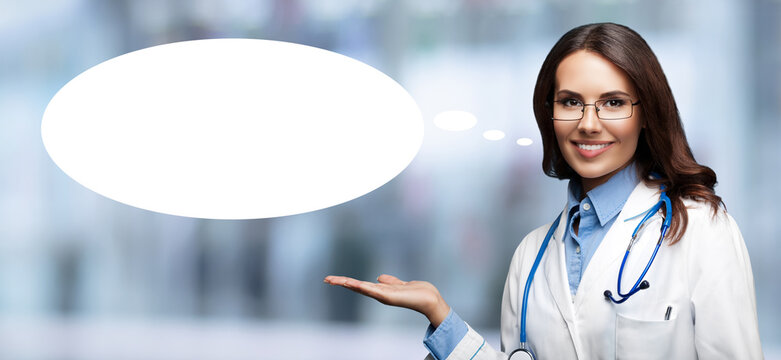 Image - happy smile doctor woman wear glasses eyeglasses, white coat, shows point white empty mockup speech bubble, blurred lab office background. Medical, clinic, healthcare ad concept