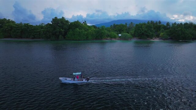 Fishing boat Yuo Island village Wewak Sepik Region aerial drone Papua New Guinea PNG Papua Niugini sunny blue sky untouched coastline beach coral reef Madang Bismarck Sea Pacific Ocean follow forward