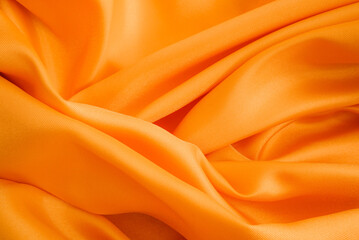 Obraz premium Orange fabric background. Satin cloth texture
