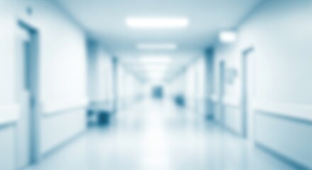 Obraz premium A long, empty hospital hallway with blue lighting and white walls.