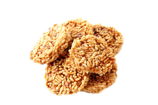 Traditional Thai crispy rice crackers coated with caramelized sugar syrup, stacked and isolated on white background. Sweet crunchy snack with golden texture, popular local dessert concept.