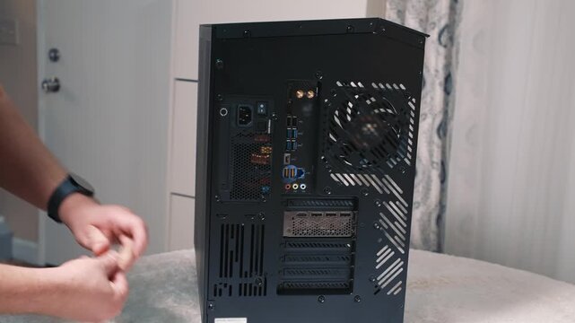 Screwing in side panel screws of desktop computer case to complete assembly and secure components in place
