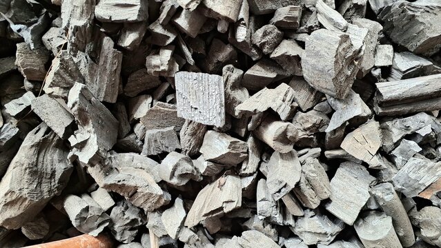 Natural charcoal pieces close up top view macro texture of black carbon for BBQ fuel grilling energy and industrial background.