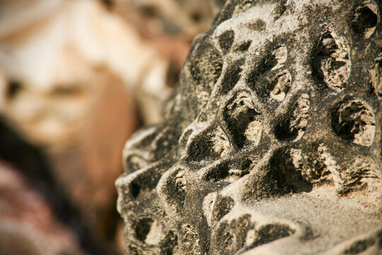 Weathered sandstone rock with honeycomb erosion patterns, coastal geology texture background.