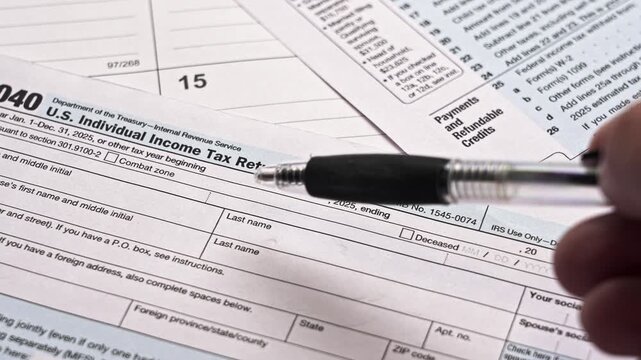 Taxpayer thinking and hesitating before filling out the united states federal income tax form 1040. Financial accounting concept for the year 2025