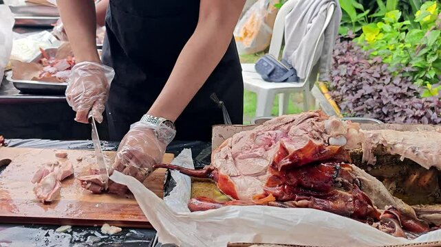 Chef Slicing Traditional Balinese Roasted Suckling Pig (Babi Guling) for Serving