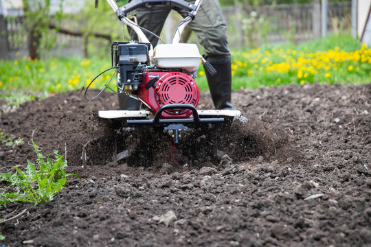 Farmer using tiller on a plowed field