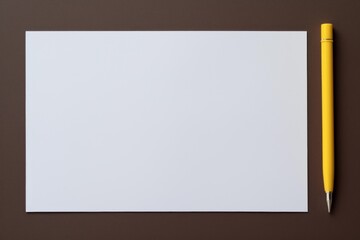 Obraz premium Blank white paper and yellow pen creating a minimalist workspace with copy space