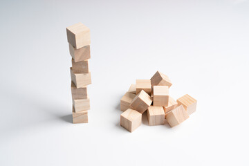 a neat pile of rough wooden cubes and a messy pile