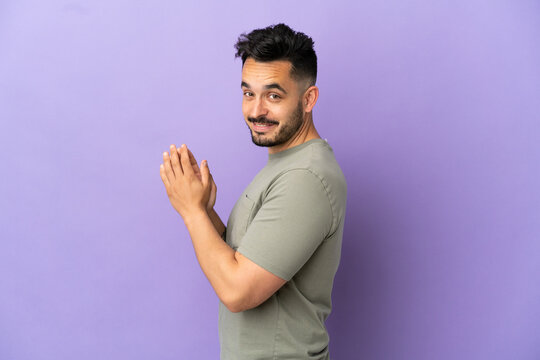 Young caucasian man isolated on purple background scheming something