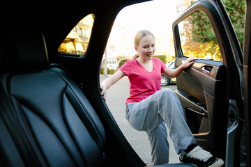 Teenage girl getting into car on residential street, growing independence concept
