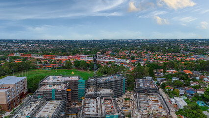 Obraz premium Panoramic Aerial Drone view of Inner Western Suburbs of Sydney housing, roof tops, the streets and the parks, the roads and trees of Ashbury Ashfield Burwood Summer Hill Canterbury and Campsie in Sydn