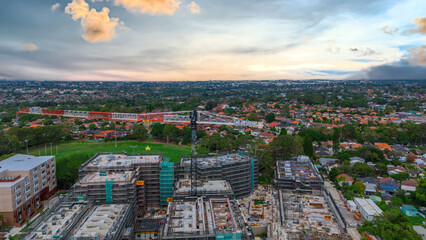 Obraz premium Panoramic Aerial Drone view of Inner Western Suburbs of Sydney housing, roof tops, the streets and the parks, the roads and trees of Ashbury Ashfield Burwood Summer Hill Canterbury and Campsie in Sydn