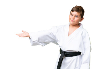 Little caucasian kid doing karate over isolated chroma key background extending hands to the side for inviting to come © luismolinero