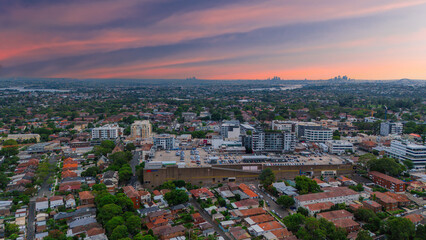 Fototapeta premium Panoramic Aerial Drone view of Inner Western Suburbs of Sydney housing, roof tops, the streets and the parks, the roads and trees of Ashbury Ashfield Burwood Summer Hill Canterbury and Campsie in Sydn