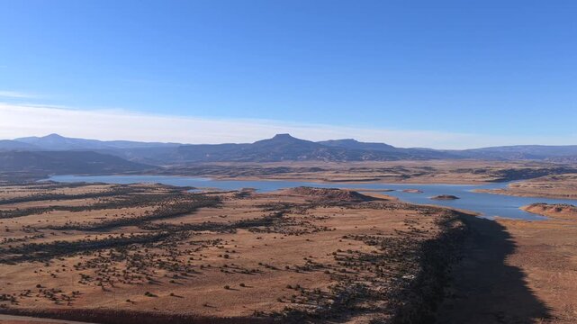 A dramatic drone flight pushes toward the iconic flat-topped silhouette of Cerro Pedernal. This cinematic 4K perspective captures the legendary New Mexico landmark and vast Southwest wilderness.