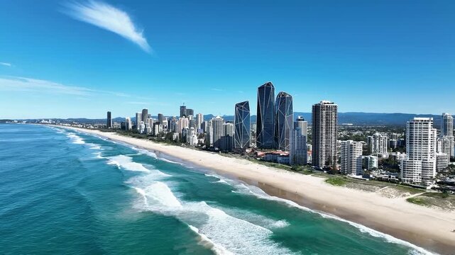 A stunning aerial panorama of Surfers Paradise Beach on a lovely summer day. Golden sand, turquoise waves, and sparkling blue ocean contrast with the vibrant city skyline &mdash; capturing the essence of Au