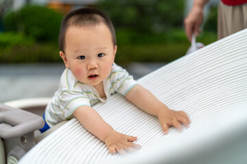 Asian boy looking at camera outdoors with round head