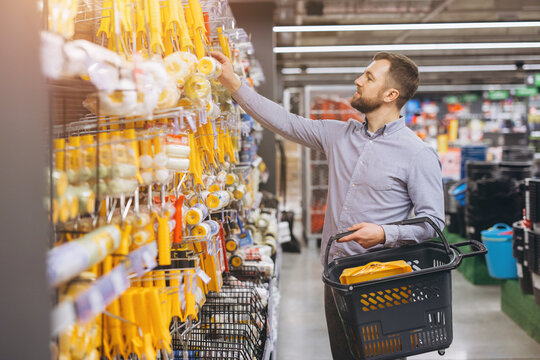 Man choosing paint roller in hardware store, shopping for home renovation and DIY projects