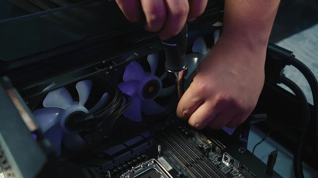 Unscrewing the screws securing the motherboard inside the desktop computer case during disassembly or component replacement
