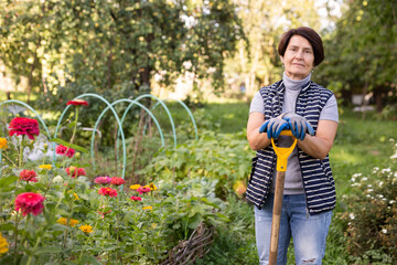 Portrait of an mature woman with shovel in backyard of country house