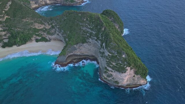 Majestic aerial view of the iconic t rex shaped cliff at kelingking beach on nusa penida island, bali, with turquoise water and waves