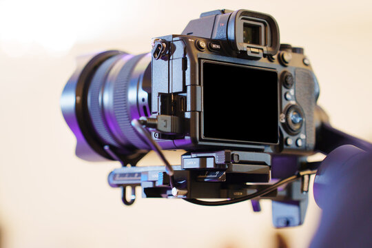 Camera on a stabilizer ready for filming indoors at a gathering event
