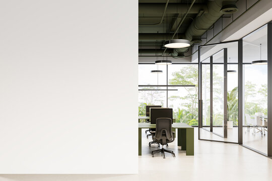 Contemporary office interior with blank wall mockup and modern workspace featuring green desks, ergonomic chairs, and large glass windows with greenery. 3D Rendering