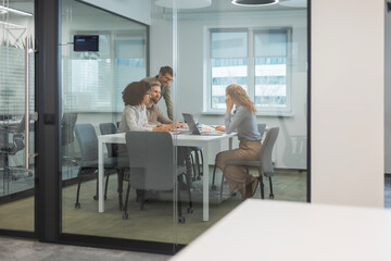 Obraz premium Job interview process is in office. Human resources, meeting and group of hiring candidates for vacancy, through a glass partition
