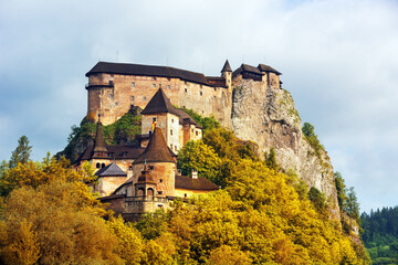 Naklejka premium „Orava Castle in Slovakia at night, famous filming location of the 1922 silent horror film Nosferatu. Dramatic gothic medieval castle on a rocky cliff with dark mysterious atmosphere.“