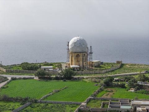 Aerial view of the iconic Meteorological Office radar dome sits majestically atop Dingli Cliffs, overlooking the azure Mediterranean Sea, Dingli, Malta.