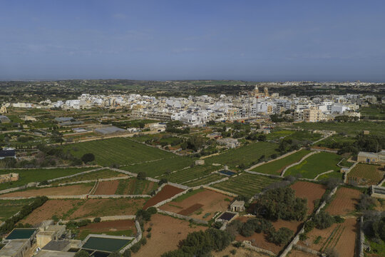 Aerial view of textured fields contrasting with the clustered buildings and the skyline, capturing the essence of the region, Dingli, Dingli, Malta.