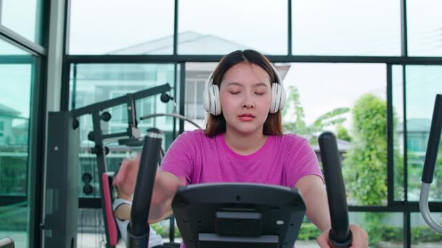 Woman Using Outdoor Rowing Machine In Park