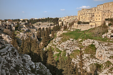 Gravina in Puglia, Bari, Italy: landscape of the canyon with the old town over the deep ravine and the ancient aqueduct bridge in the background